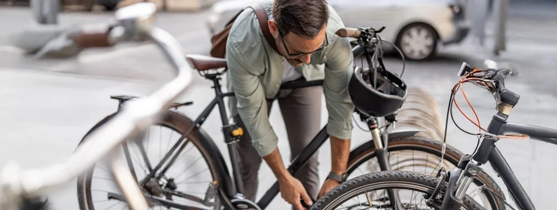 Businessman locking his bicycle at a bike rack in the city. Does Renters Insurance Cover a Stolen Bike?