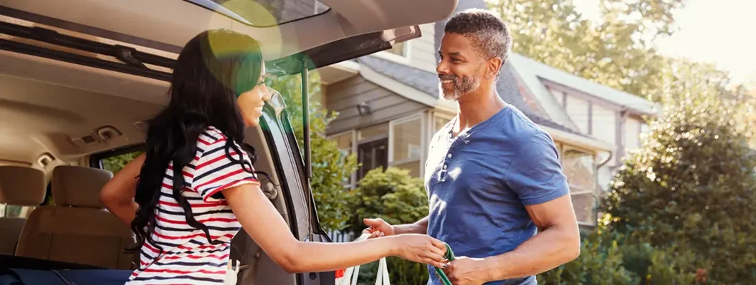 Couple Unloading Shopping Bags From Car into Home. Find Pennsylvania umbrella insurance.
