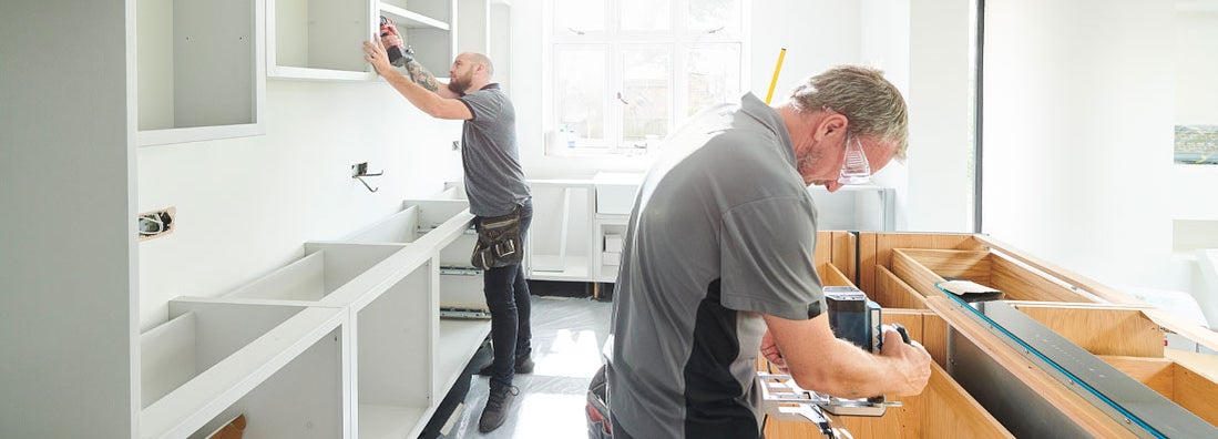 Two joiners installing kitchen cabinets. Find cabinet installation company insurance.
