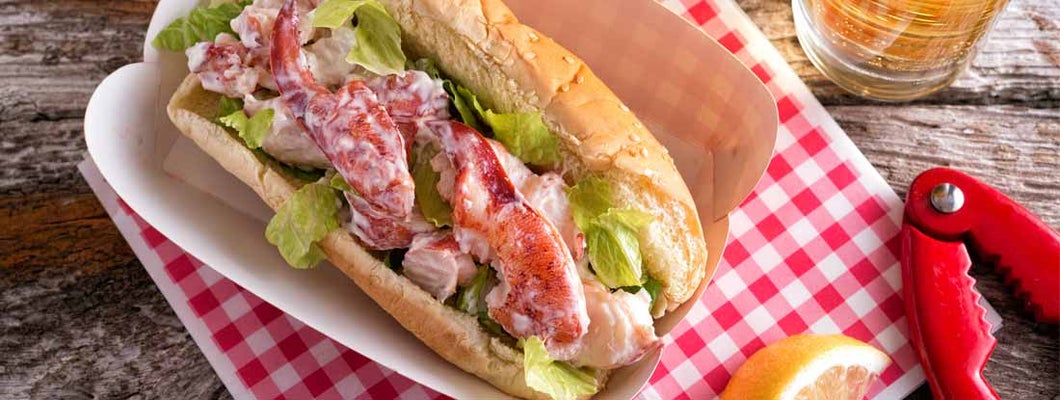 A delicious lobster roll on a rustic wood table top