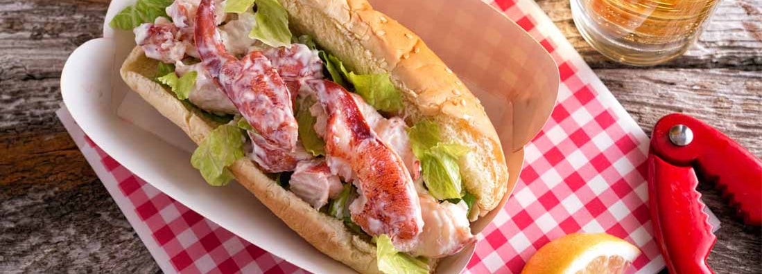 A delicious lobster roll on a rustic wood table top