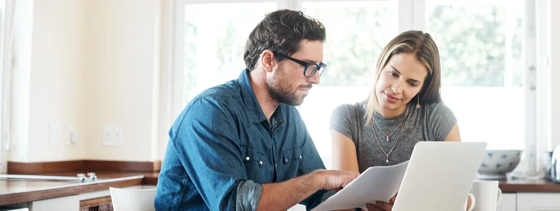 Shot of a young couple comparing umbrella insurance together. Find Umbrella Insurance.