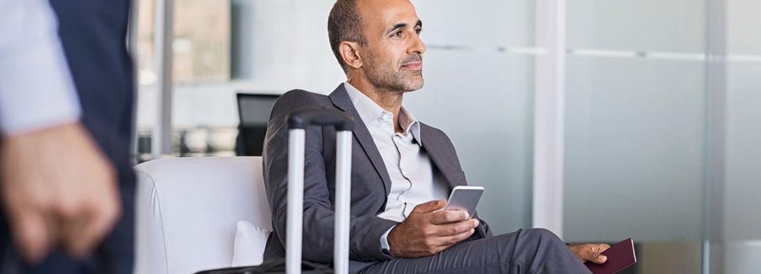 Businessman waiting at airport. Find travel management service insurance.