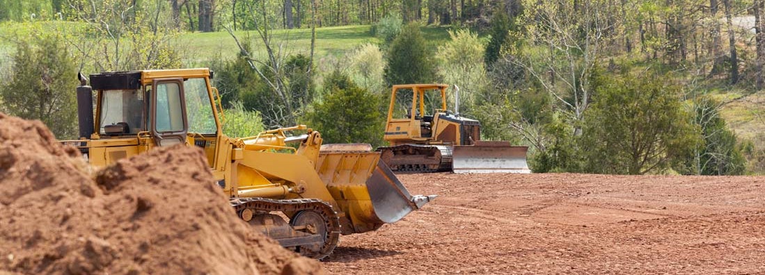 Large earth mover digger clearing land. Find land clearing contractor insurance.