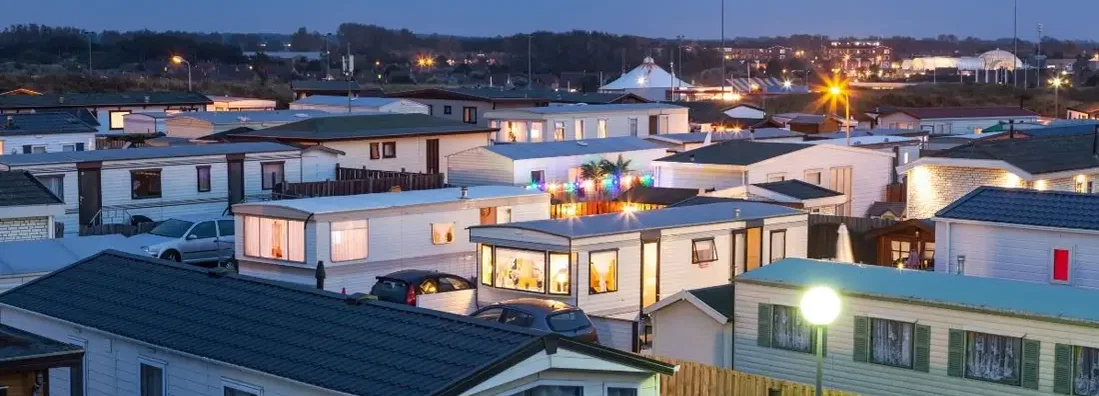 Mobile homes on a trailer park at dusk. Find Mobile Home Park Insurance.