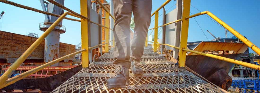 Engineer walking on the steel bridge cross over at workplace. Find Best Companies Workers' Compensation.