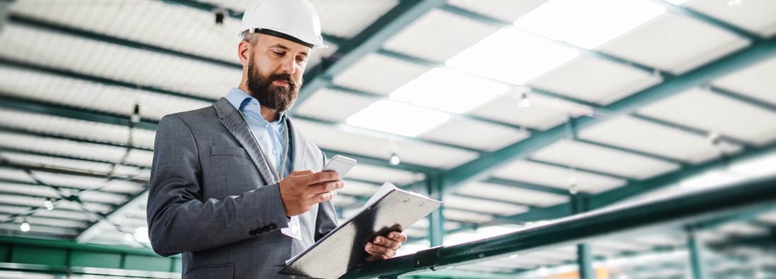 Industrial man engineer with smartphone in a factory. How to file for workers' compensation.