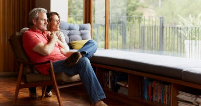 Thoughtful mature couple relaxing by window at home. 7 Delightful Upsides to Downsizing. 