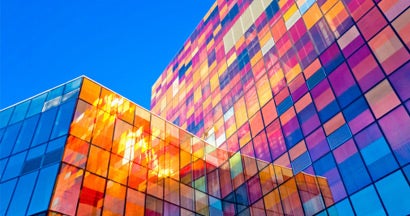 Multi-colored glass wall of business building. Find business insurance.
