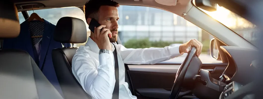 Businessman using phone in the car. Find Lake Mary, Florida car insurance.