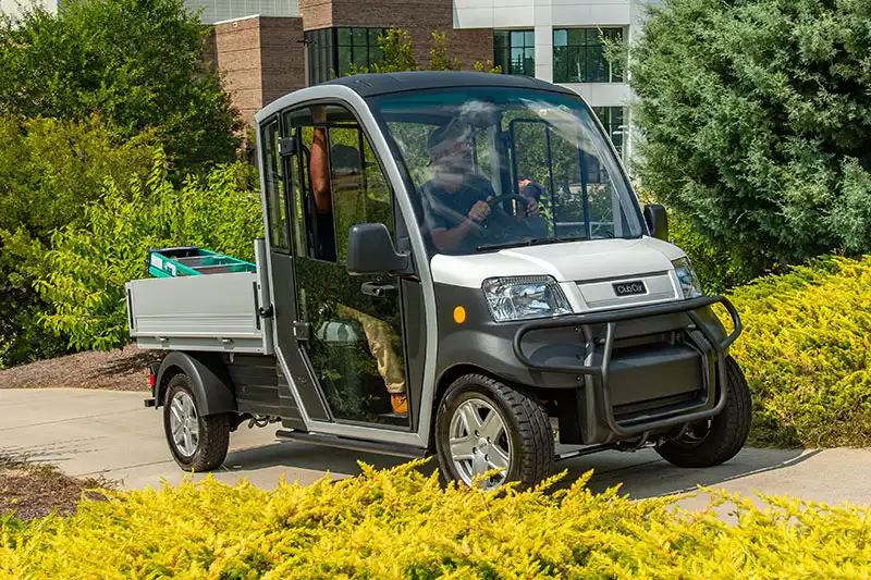 Club Car Urban electric work truck driving on university campus