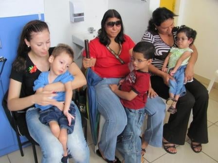 Drie moeders wachten met  hun kind in een gang op de begeleiders