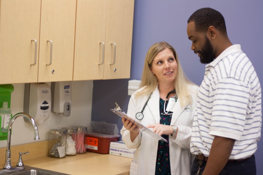 Physician discussing results with man in wellness center