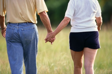 Image of man and woman holding hands and walking.