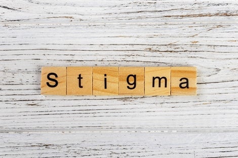 Scrabble tiles that spell out "stigma."