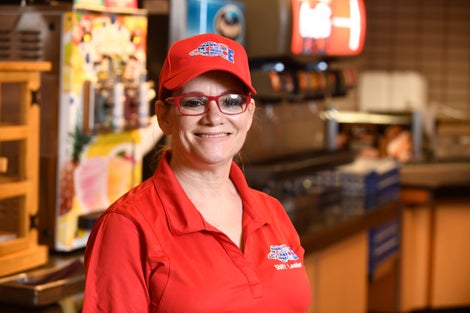 Woman in red cap and shirt wearing glasses.