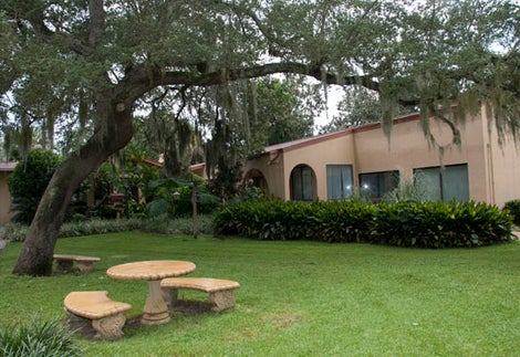 The Friary at Lakeview Center courtyard with benches, trees and Friary building.