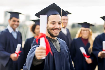 Graduate hold up certificate and smiles.