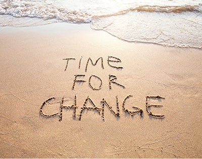 Time for change is written in beach sand.