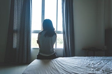 Women sitting on bed looking out the window