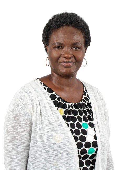 African American woman with short hair and hoop earrings and wearing a white sweater.