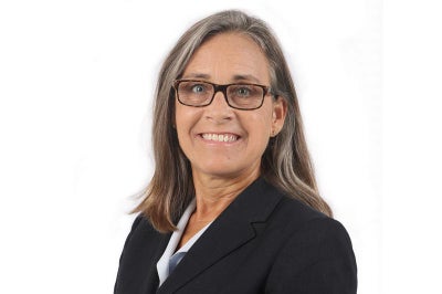 Woman wearing glasses and black jacket.
