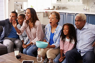 Family enjoys watching a TV program - perhaps rooting on their favorite sports team.