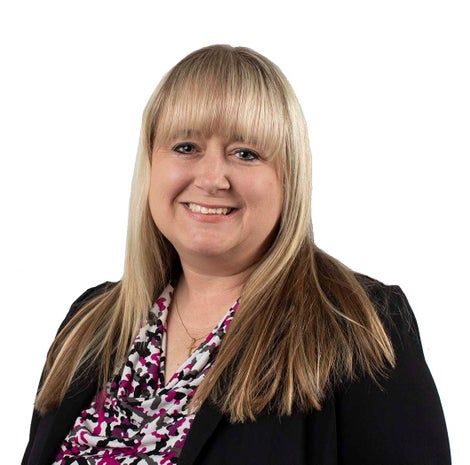 Professional photo of woman with long blond hair wearing a black suit.