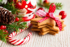 Image of candy cane, Santa ornament and stack of ginger bread cookies shaped like stars.
