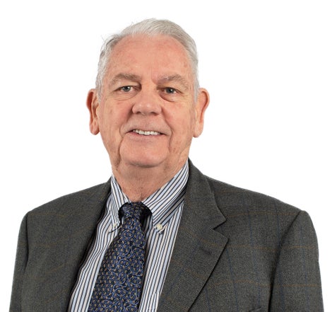 Man with gray hair wearing tie and suit jacket.