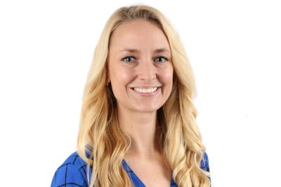 Young woman with long blonde hair smiles at the camera.
