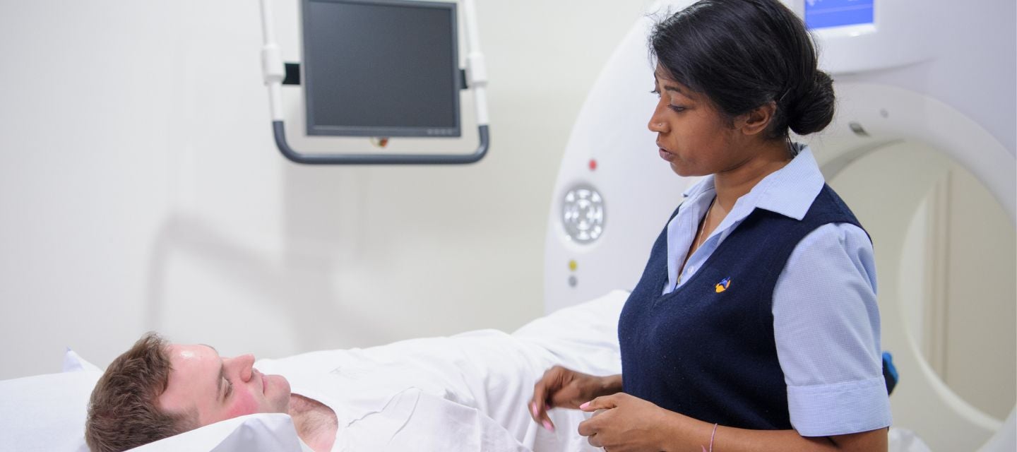 An I-MED radiology technician attends to a patient receiving a CT scan