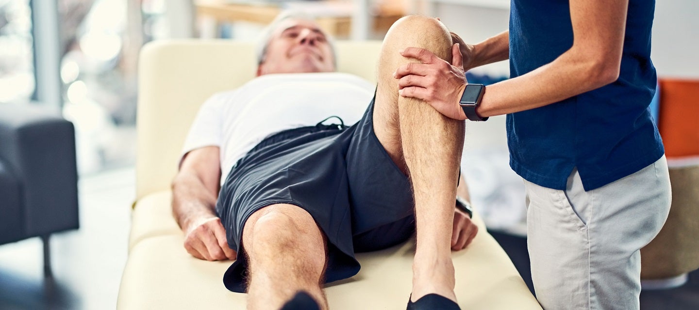 Patient with knee injury on treatment table at medical practice