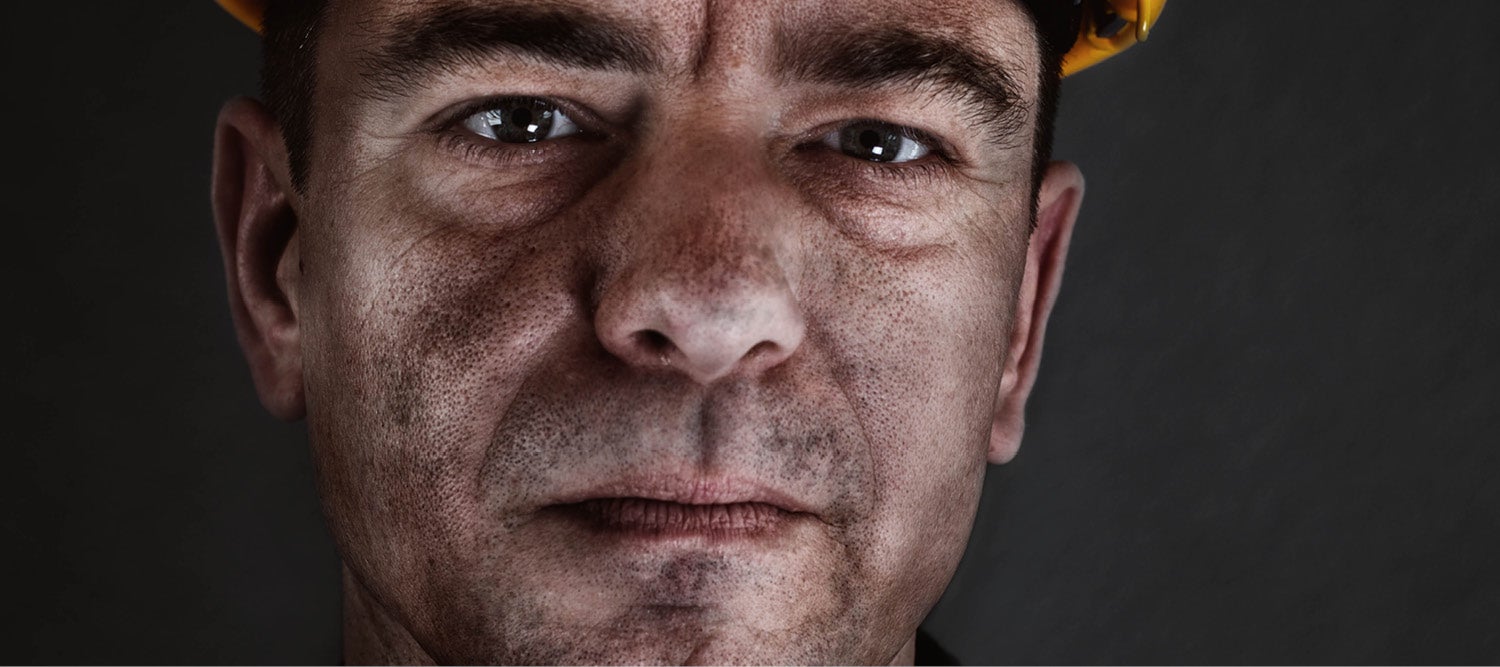 Mine worker looking directly into camera and wearing a hard hat