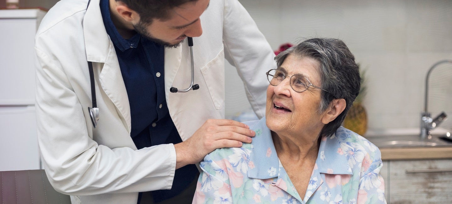 Doctor comforts elderly woman 