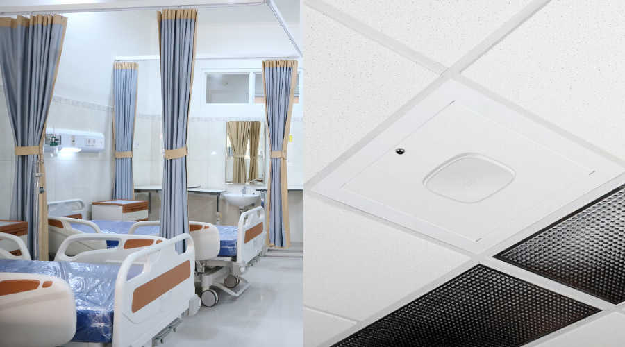 Healthcare patient room with beds and privacy curtains on the left, and a wireless access point mounted in a ceiling tile on the right.
