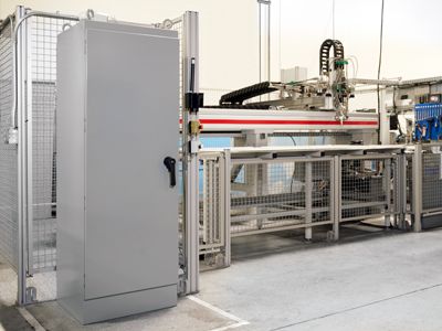 A RMR Industrial NEMA Enclosure from Chatsworth Products is prominently displayed in a factory, with automated equipment and metal fencing in the background, showcasing a clean and organized industrial setup.