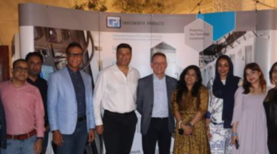 A group of people posing in front of a Chatsworth Products display.