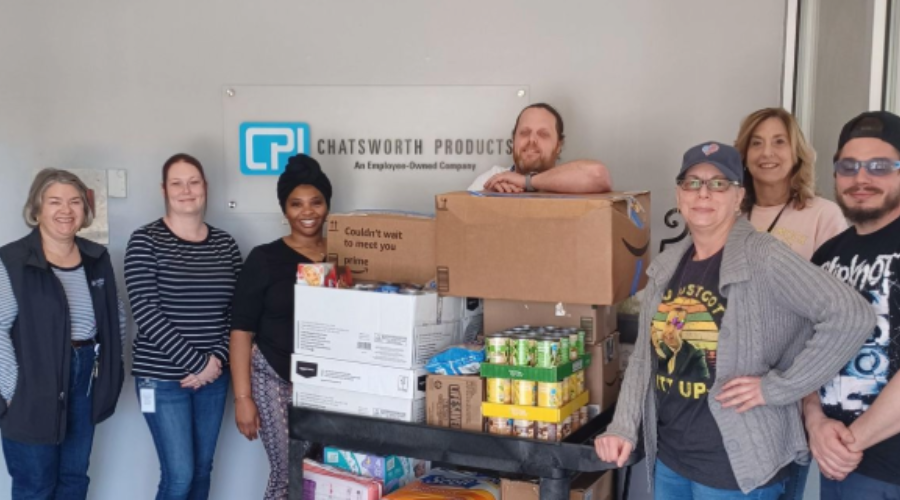Group of Chatsworth Products employees standing next to a cart filled with donated food items.