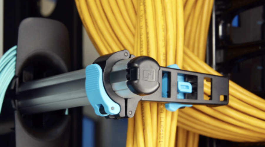 Close-up of an efficient cable management system with neatly organized yellow cables and a secure locking clip.