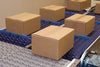 Brown cardboard case packages on roller top conveyors