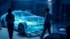Silhouettes d'une femme et d'un homme debout à côté de l'hologramme d'une voiture