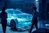 Silhouetted woman and man standing next to hologram of car