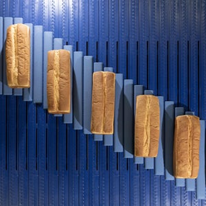 Draufsicht auf Brotlaibe, die über die AIM Glide-Verteilweiche laufen