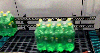 Eight-pack of green plastic bottles on ARB conveyor