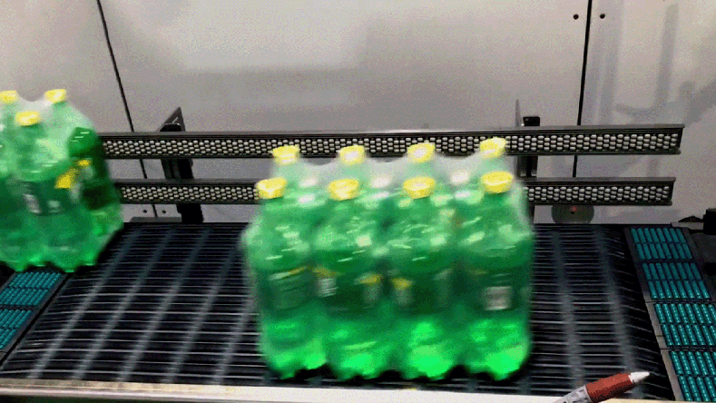Eight-pack of green plastic bottles on ARB conveyor