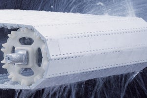 Conveyor belt being sprayed with EZ Clean system