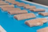 Filetes de pescado redondeados de color carne en una banda ThermoDrive