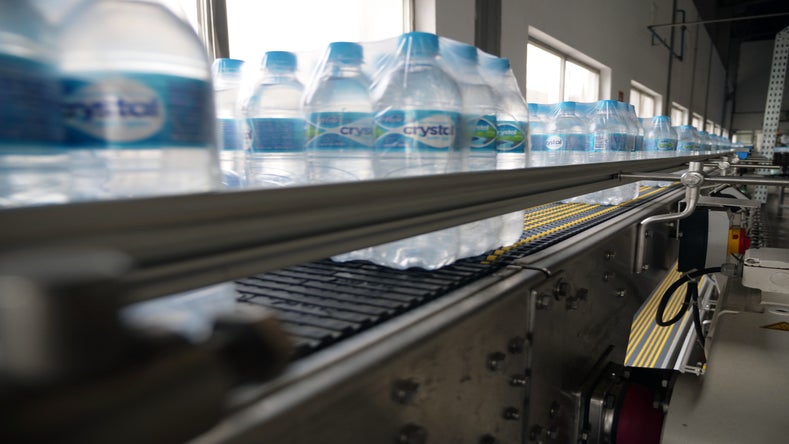 Bundles of bottle water on roller and friction top conveyor belts