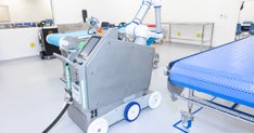 CleanBotix robot, “Rosie,” which automates the hose work in wet cleaning, positioned next to a conveyor